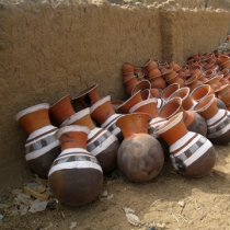 Dozens of colorful water storage pots near the outskirts of a village. These are for sale, but rarely seen in homes due to their high cost. 